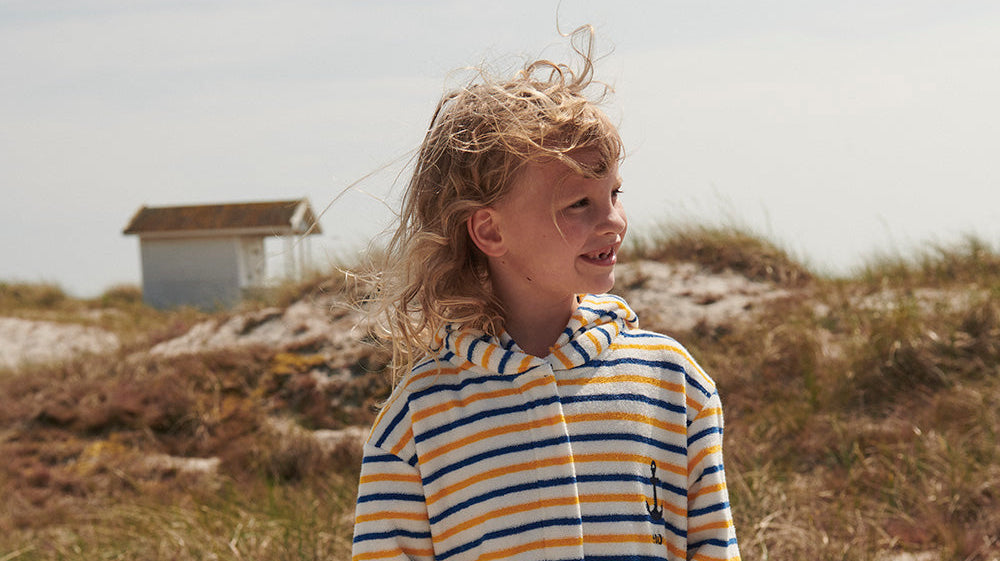 Baby i fleeceoverall och mössa från ebbe