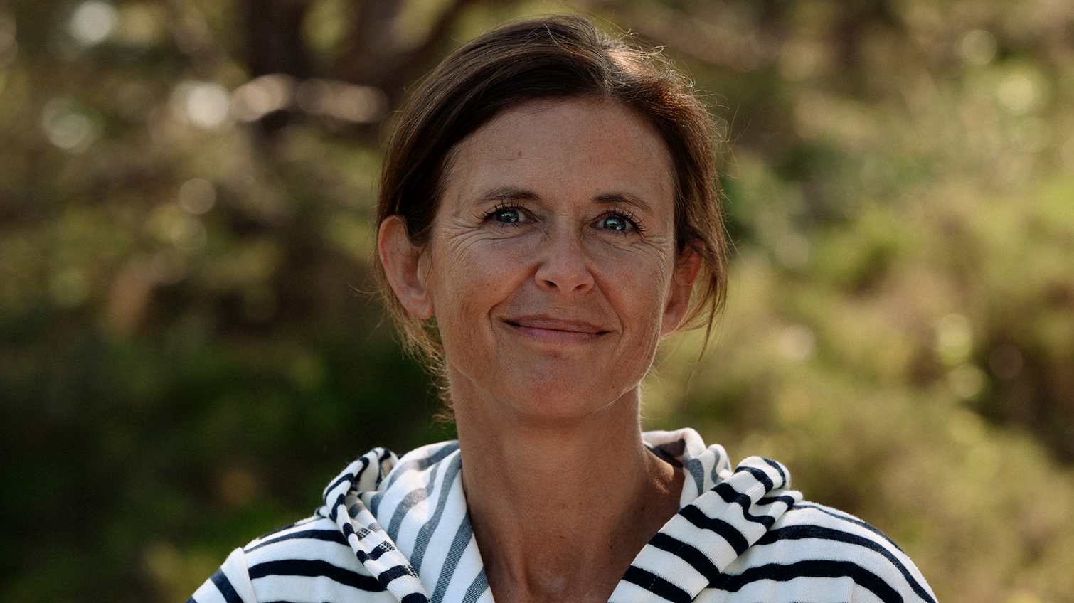 Vuxen och barn i badrock på en brygga i kvällsljus