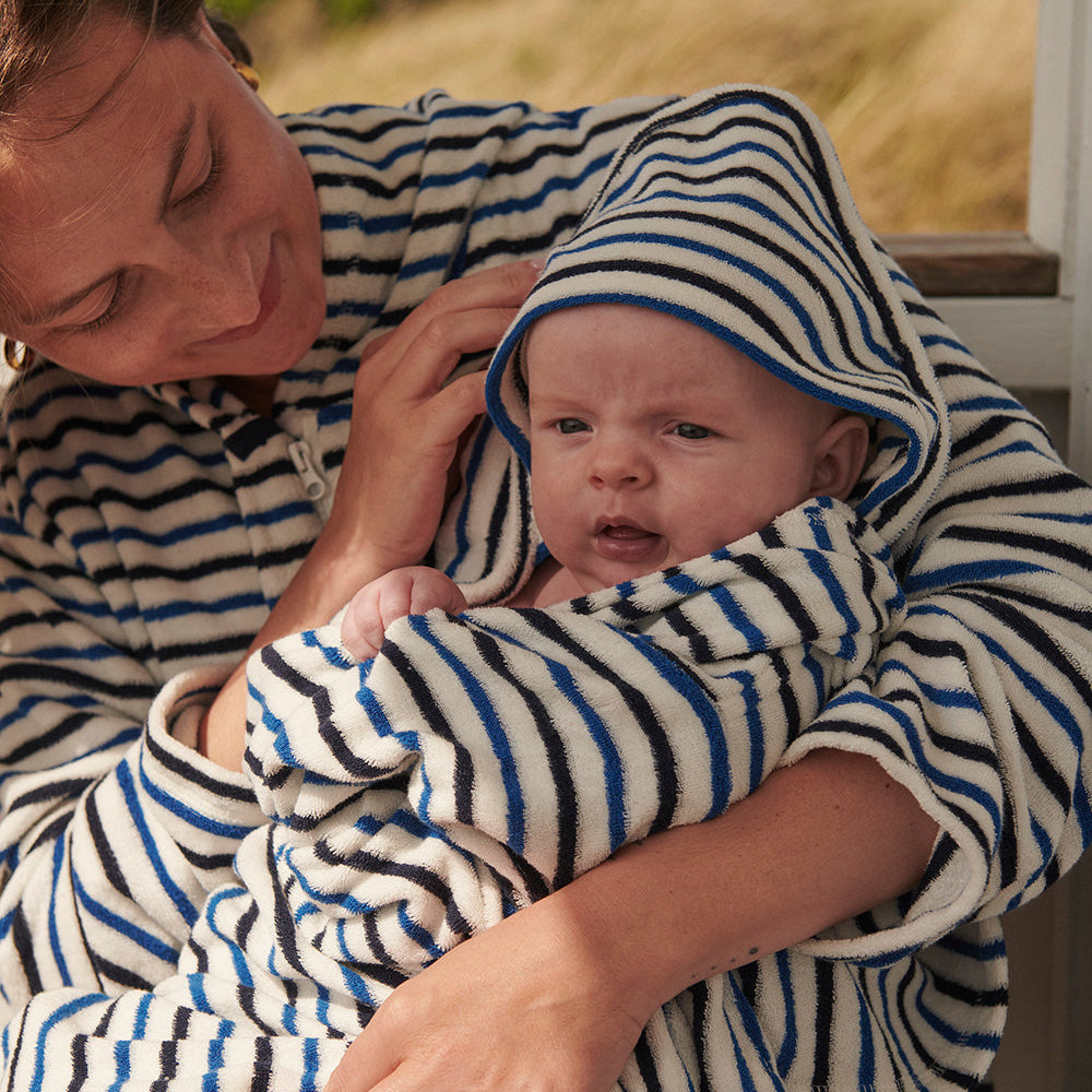 Nyfödd baby insvept i handduk med huva